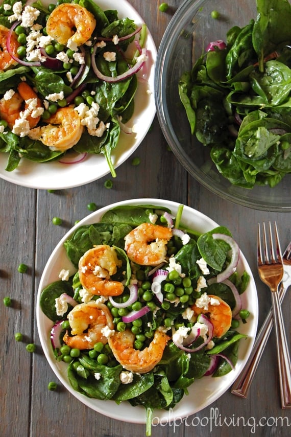 Spinach pea salad in a bowl topped off with cooked spinach and peas