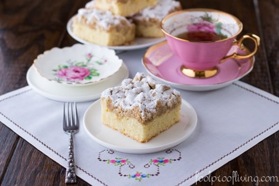 Crumb Cake sliced an placed on a small plate with a cup of tea.