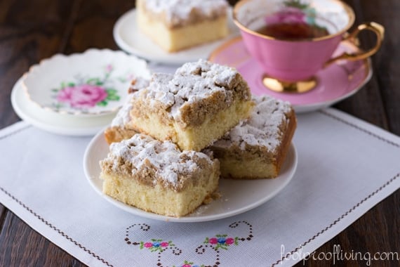 A few slices of cake placed on top of each other with tea on the side