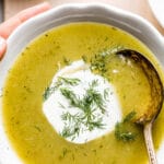 Creamy zucchini soup in a bowl with text on the image