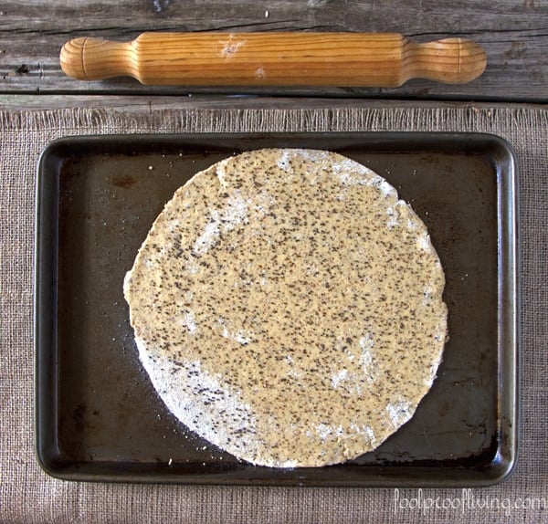 spinach flatbread dough with a wooden dough roller