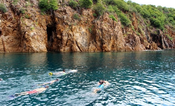People are snorkeling in the blue waters of the Caribbean Sea