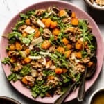 roasted butternut squash and arugula salad on a plate from the top view