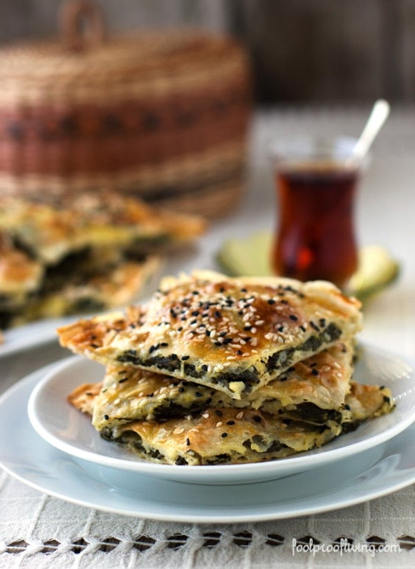 A few slices of Spinach and Feta Cheese Börek with Turkish tea in the background - how to make borek