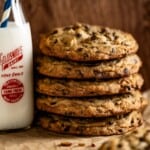 Several Doubletree cookies next to a jar of milk.