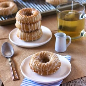 ina garten baked cinnamon doughnuts placed on a plate with tea in the background