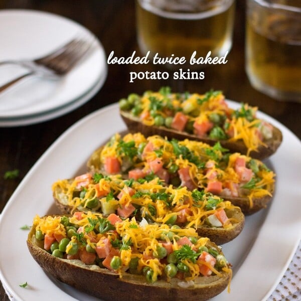 4 Loaded Twice-Baked Potato Skins on a plate with a glass of beer on the side