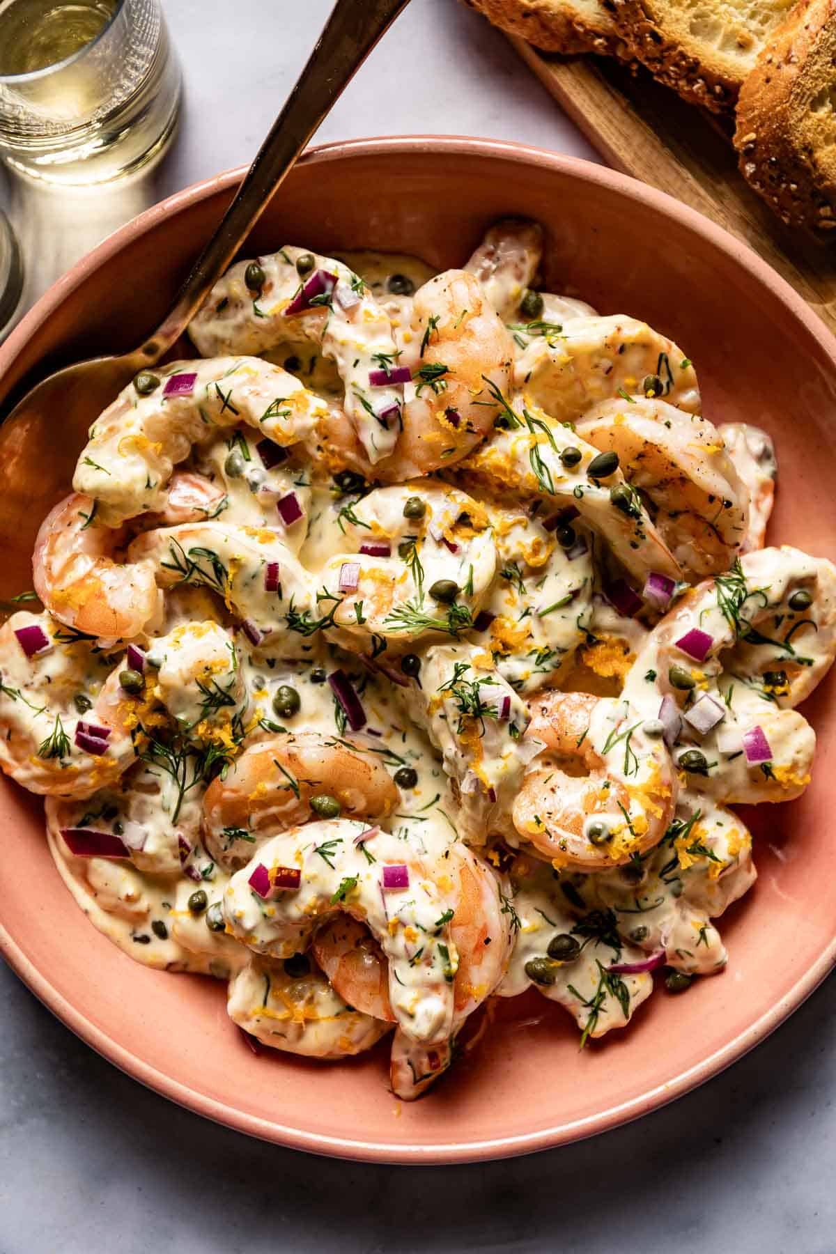 Ina Garten roasted shrimp salad in a bowl with a spoon on the side.