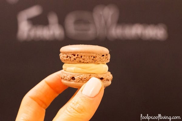 a woman is holding a macaron in her hand