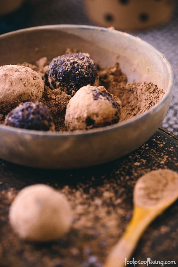 Four Vegan Cocoa Truffles in a bowl with vegan cocoa powder