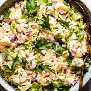 Shrimp Orzo Salad in a bowl with two spoons on the side