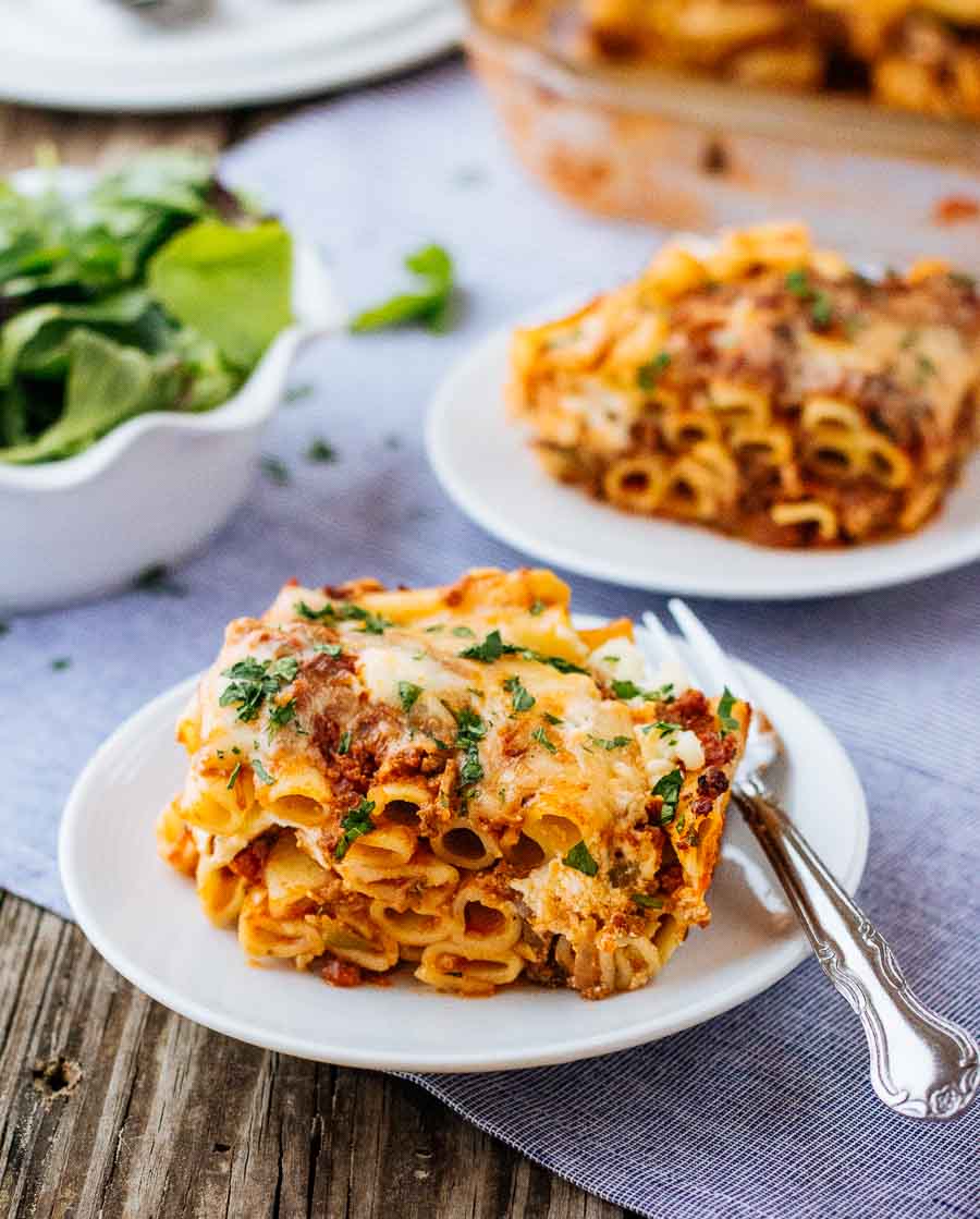 A portion of ground beef pasta is placed on a plate and photographed from the front view.