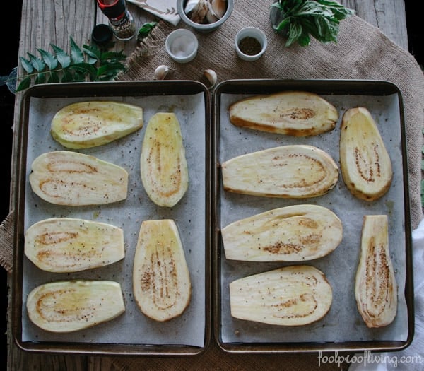 sliced eggplant on a baking sheet lightly oiled and seasoned with salt and pepper