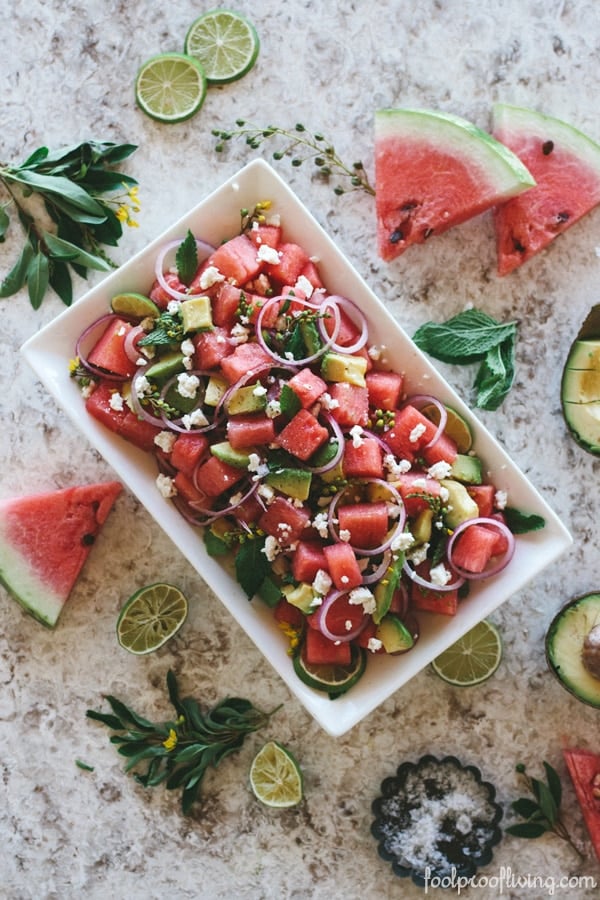 Watermelon Salad with avocado with sliced lime around the serving plate