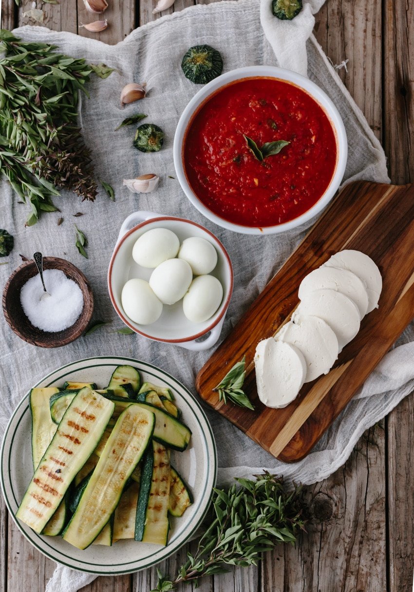 All ingredients to make zucchini lasagna are laid out.