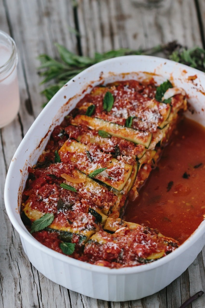A large casserole dish with half eaten zucchini lasagna