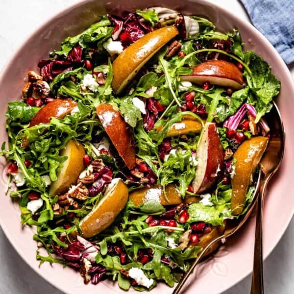 Roasted pear salad in a bowl with spoons on the side