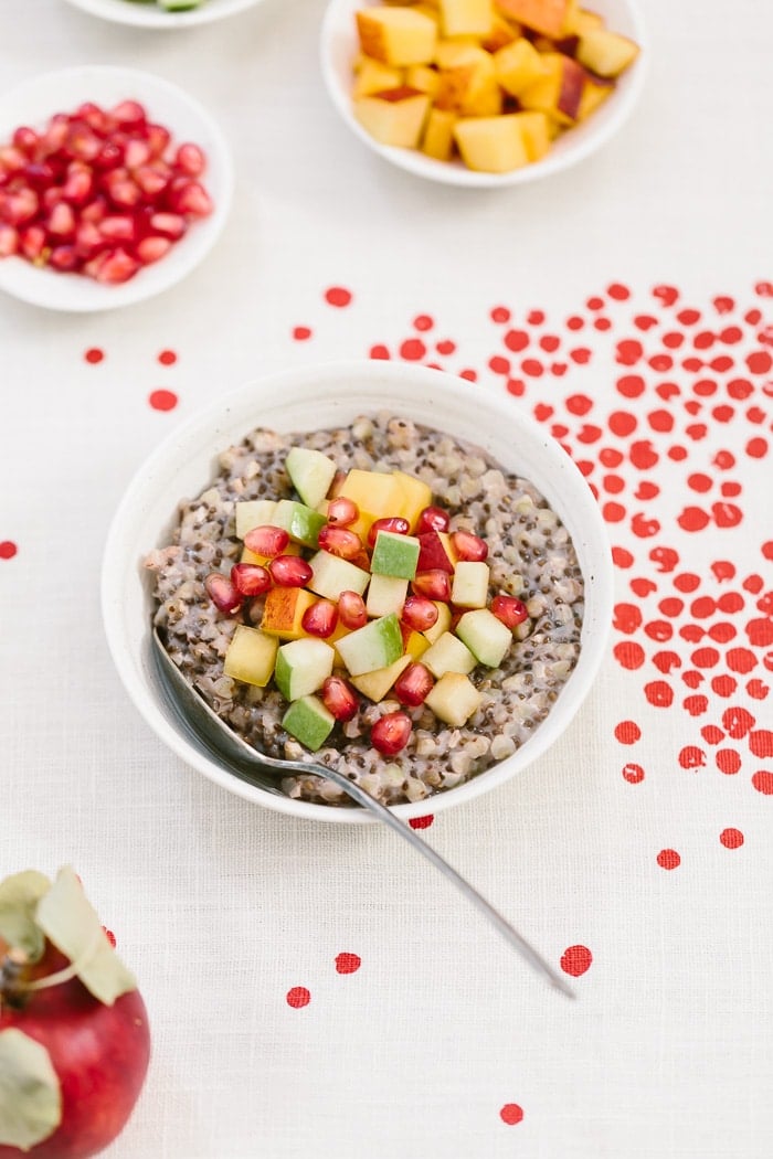 A bowl of overnight buckwheat groats are placed in a bowl and topped off with fruit