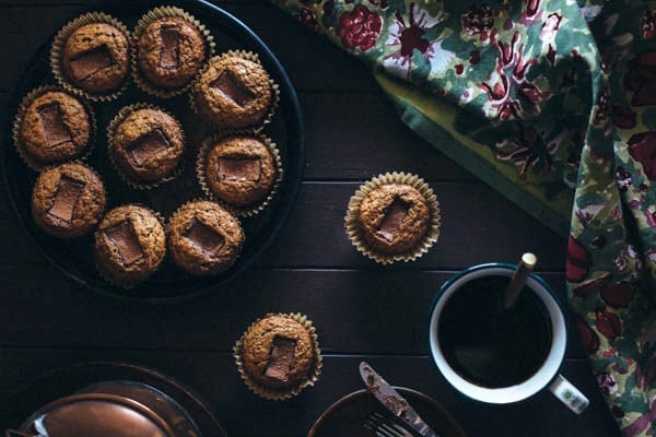 Several Banana Muffins with Toblerone Chunks with a cup of coffee