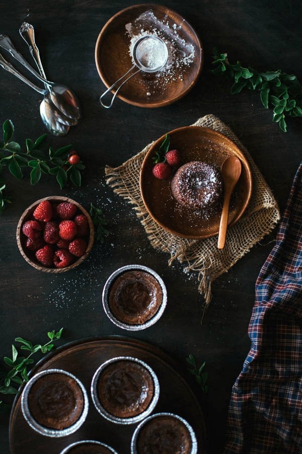 Overhead view of Chocolate Fondant with strawberries, flatware and garnishes on the side