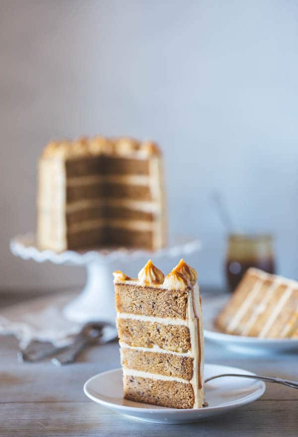 A slice of Banana Cake with Caramel Frosting with slices in the background