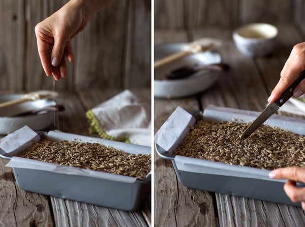 a woman is putting seasoning on top of the bread and the coring it with a knife