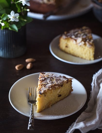 A sliced ricotta almond flour cake from the front with a fork on the side
