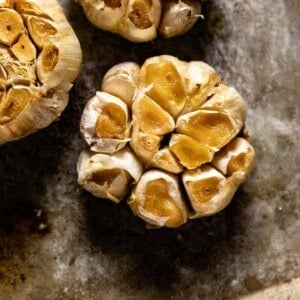 roasted garlic cloves on a baking sheet from the top view.