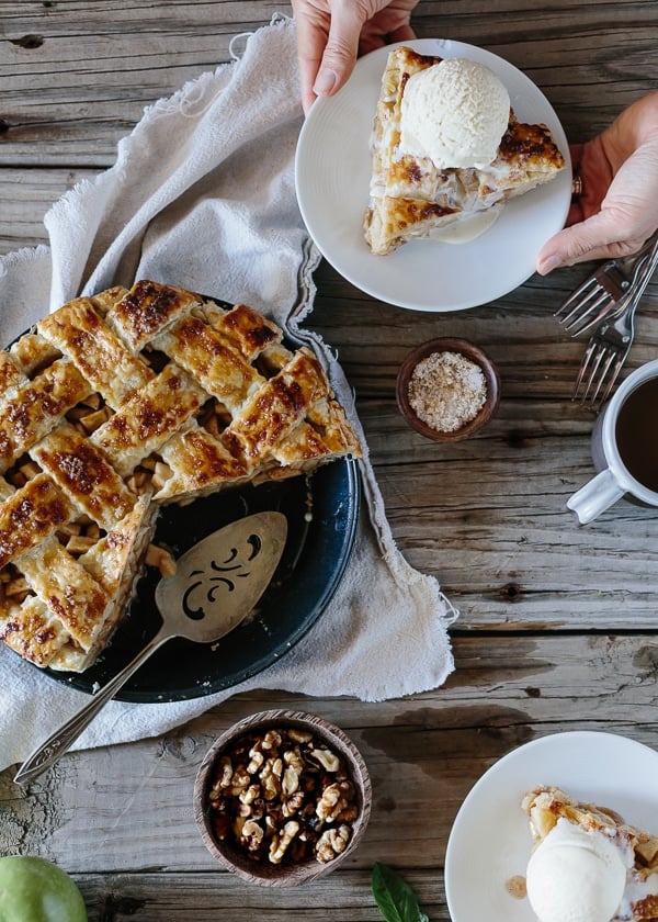 Sliced Caramel Apple Pie a slice with ice cream on top on a small plate and flatware