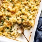 Cauliflower Au Gratin in a baking dish with a spoon on the side.