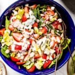 Strawberry Spinach Salad with Poppy Seed Dressing placed in a large bowl with ingredients around it