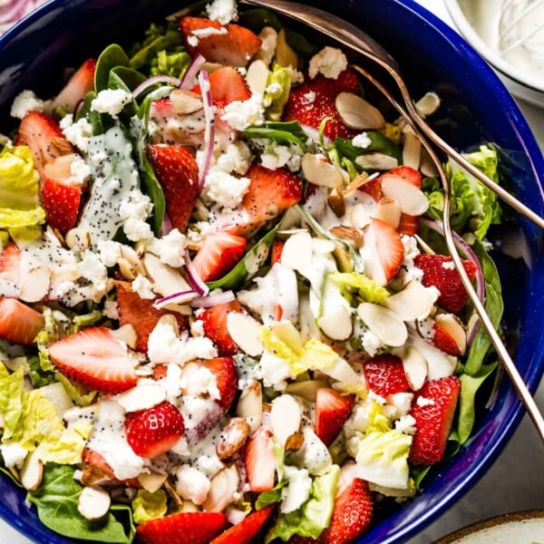 Strawberry Spinach Salad with Poppy seed dressing in a bowl with two spoons on the side