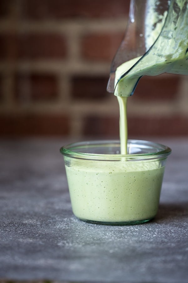 Green Cashew Sauce being poured in a small jar