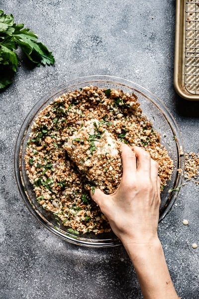 person dipping in breading for baked fish fillets 