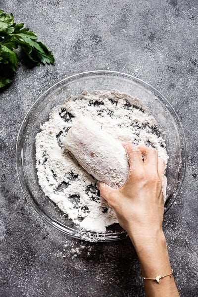 Person showing How to season fish by dreading it in flour