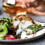 breaded fish on a plate with salad on the side