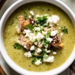 Broccoli Feta Soup in a bowl garnished with feta and parsley.