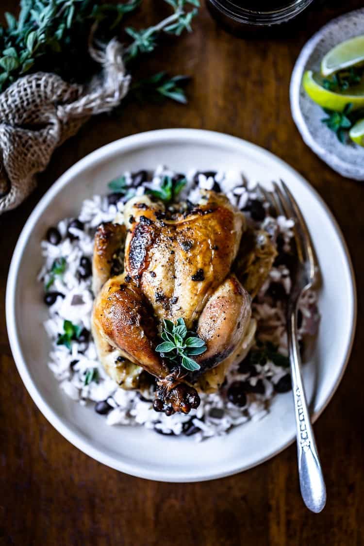 Baked Cornish Hen placed on a bed of rice with black beans