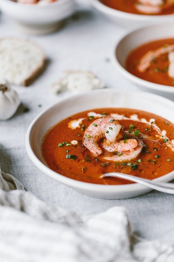 A big bowl of Tomato Soup with shrimp is topped off with Cumin Roasted Shrimp and photographed from the close view