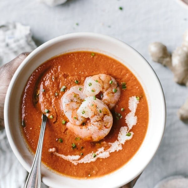 Curry Tomato Soup with shrimp is served by a person from the top