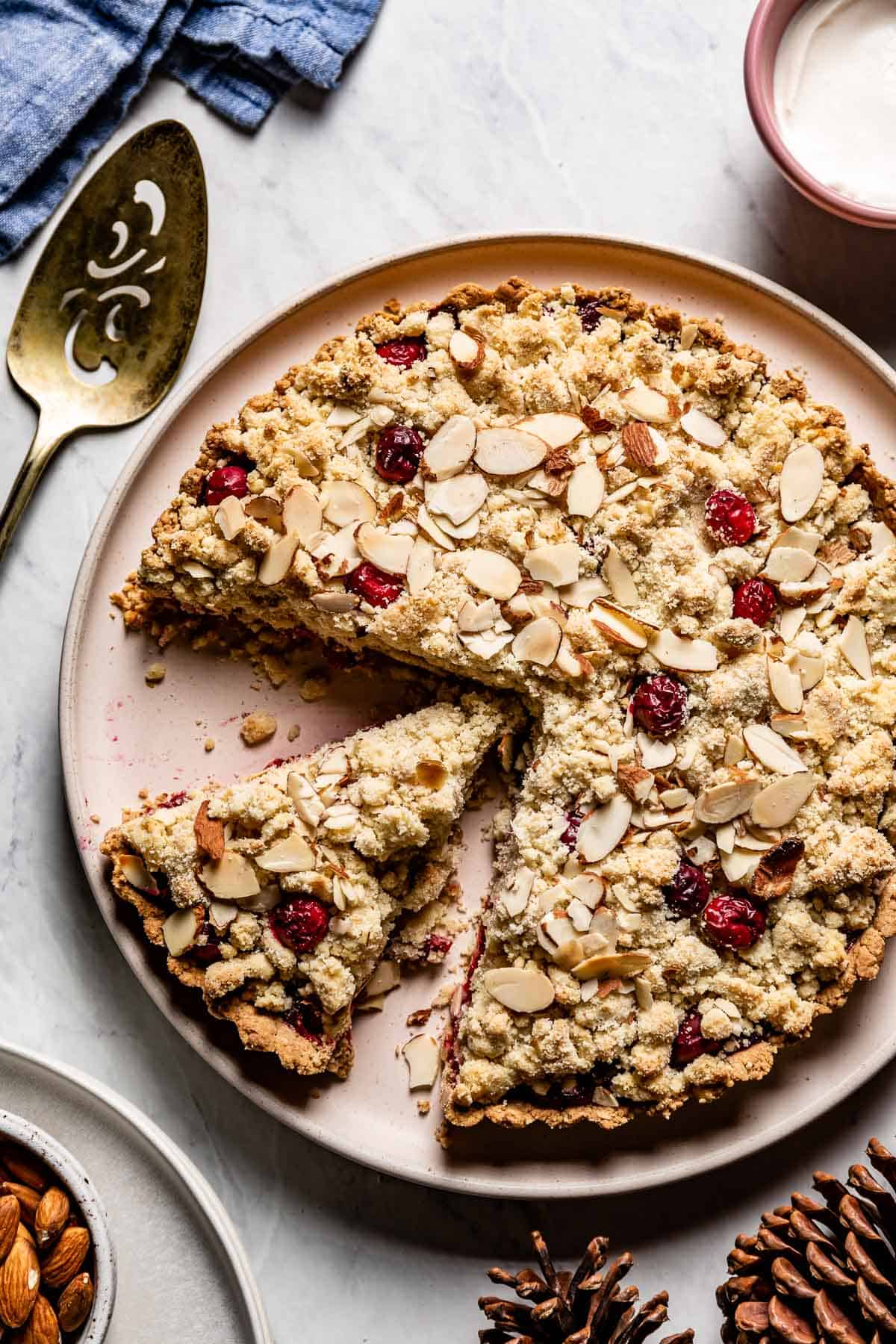 Cranberry almond flour tart with a slice cut from the top view.