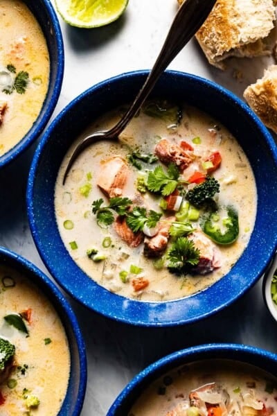 Salmon coconut soup in bowls with bread on the side.