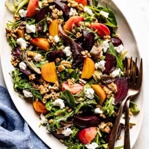 Beet Salad with Goat Cheese and walnuts with utensils on the side.