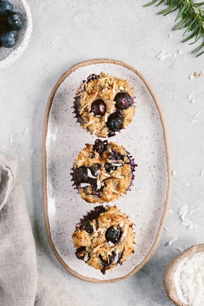 three coconut flour blueberry muffins placed on a plate