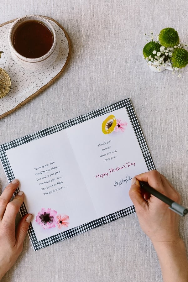 A woman is writing a greeting card