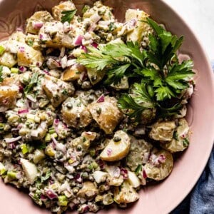 potato salad with capers and parsley in a bowl from the top view