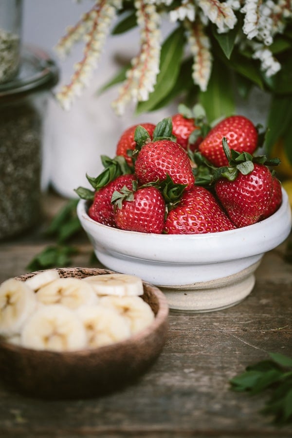 Ingredients for Strawberry Banana Yogurt Smoothie with a bowl of strawberries and bananas are photographed from the front view.