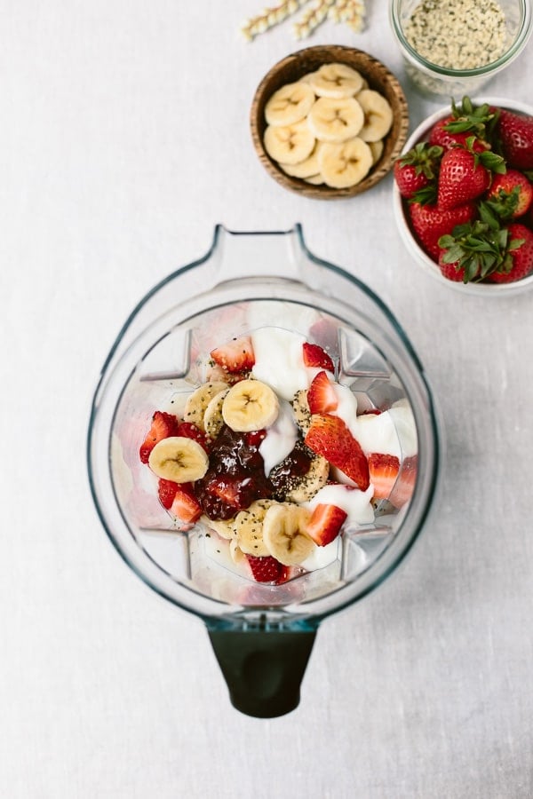 Strawberry Banana Yogurt Smoothie ingredients are photographed from the top view in a blender.