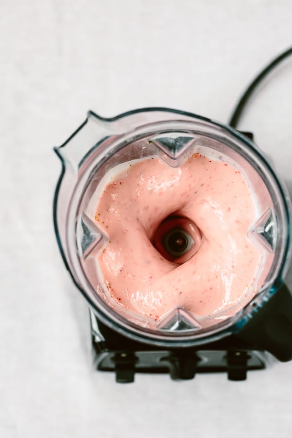 Strawberry Banana Yogurt Smoothie is photographed from the top view as it is mixing in a blender.