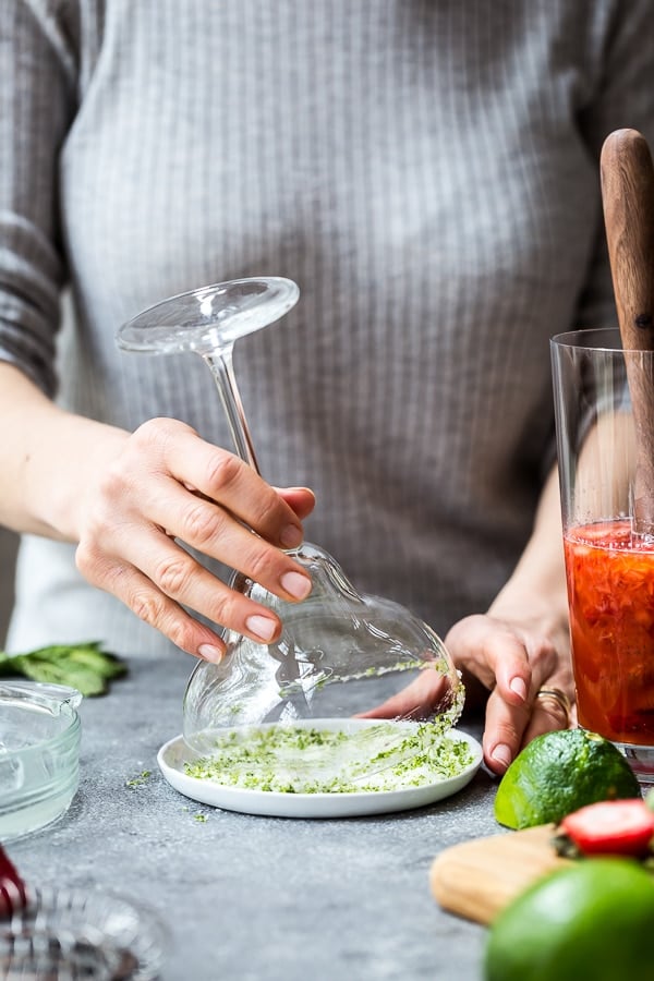 person dipping the margarita glass in salt